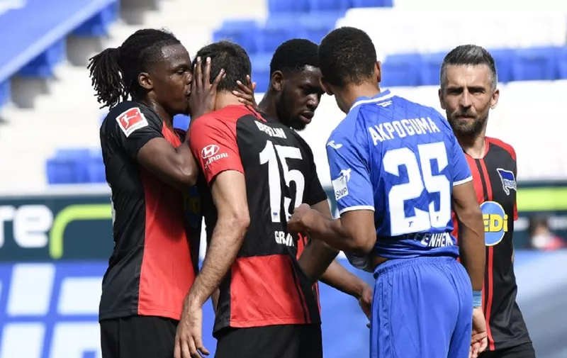 Hertha's Belgian defender Dedryck Boyata (L) talks to teammate Serbian midfielder Marko Grujic during the German first division Bundesliga football match TSG 1899 Hoffenheim v Hertha Berlin on May 16, 2020 in Sinsheim south-western Germany as the season resumed following a two-month absence due to the novel coronavirus COVID-19 pandemic. (Photo by THOMAS KIENZLE / various sources / AFP) / DFL REGULATIONS PROHIBIT ANY USE OF PHOTOGRAPHS AS IMAGE SEQUENCES AND/OR QUASI-VIDEO