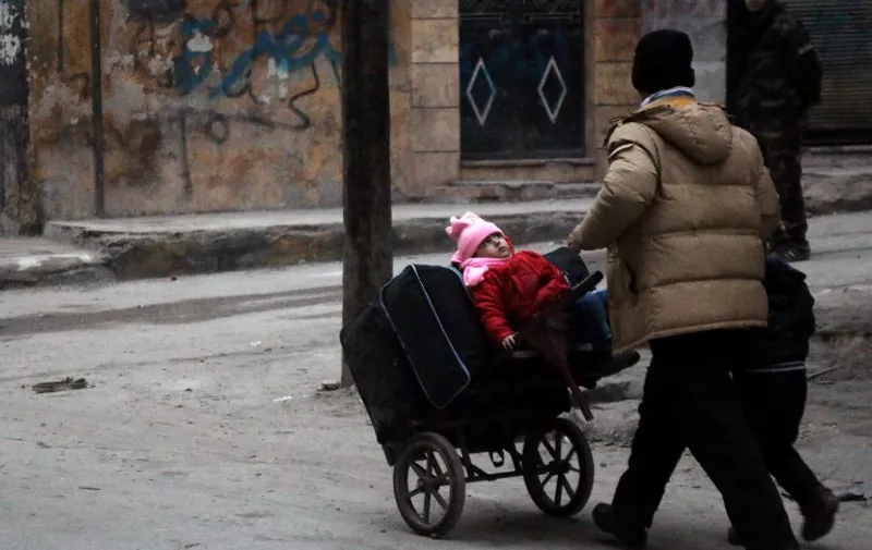 Syrian civilians flee the Sukkari neighbourhood towards safer rebel-held areas in southeastern Aleppo, on December 12, 2016, during an operation by Syrian government forces to retake the embattled city. 
The crucial battle for Aleppo entered its "final phase" after Syrian rebels retreated into a small pocket of their former bastion in the face of new army advances. The retreat leaves opposition fighters confined to just a handful of neighbourhoods in southeast Aleppo, the largest of them Sukkari and Mashhad.



 / AFP PHOTO / STRINGER