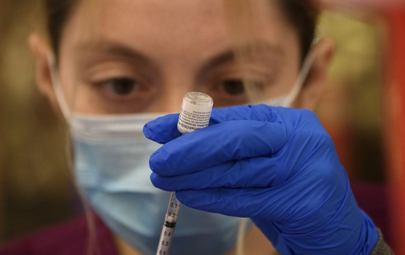 A health care worker prepares a dose of the Pfizer Covid-19 vaccine after it was approved for use by the FDA in children 12 and over at a Los Angeles County mobile vaccination clinic on May 14, 2021 in Los Angeles, California. (Photo by Patrick T. FALLON / AFP)
