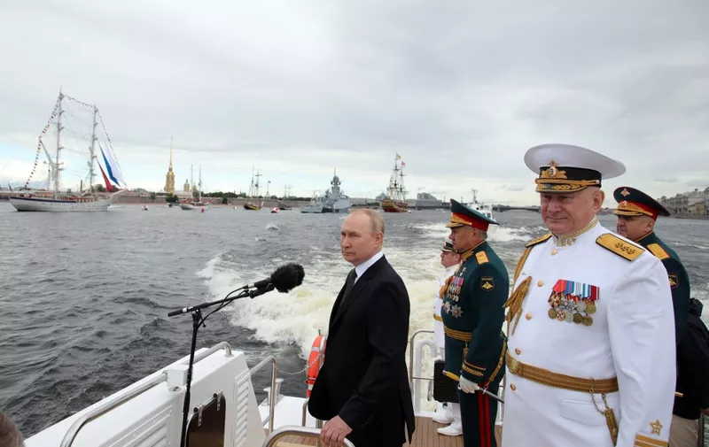 (FILES) Russia's President Vladimir Putin (L) stands next to Russia's Defence Minister Sergei Shoigu (C) and Commander-in-Chief of the Russian Navy, Admiral Nikolai Yevmenov (R) as he takes part in the main naval parade marking the Russian Navy Day, in St. Petersburg on July 31, 2022. The Kremlin on March 11, 2024 declined to comment on reports it had sacked the commander-in-chief of its navy after losing a string of warships to Ukrainian attacks in the Black Sea. Several news outlets including the pro-Kremlin Izvestia newspaper said over the weekend that Admiral Nikolai Yevmenov had been replaced by Northern Fleet commander Alexander Moiseyev. (Photo by Mikhail KLIMENTYEV / Sputnik Host Photo Agency / AFP)