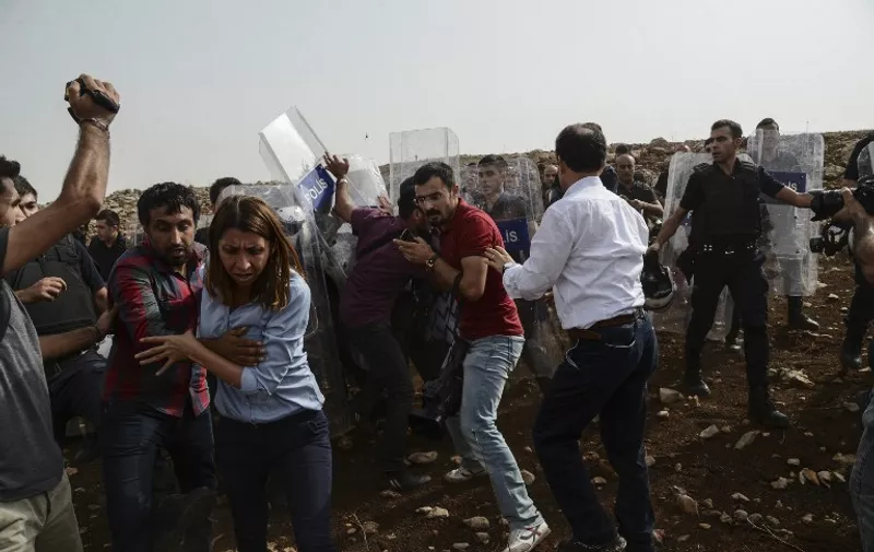Members of Turkey's main pro-Kurdish Peoples' Democratic Party (HDP) clash with Turkish police as they try to enter Kurdish town Cizre blocked by Turkish police, on September 10, 2015, in Sirnak. HDP co-chairman Selahattin Demirtas has been leading fellow deputies and dozens of supporters on a march to Cizre to end the curfew and draw attention to the plight of its 120,000 residents. AFP PHOTOS/ILYAS AKENGIN