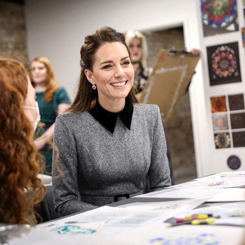 Britain's Catherine, Duchess of Cambridge, meets students from The Prince's School of Traditional Arts working on geometry and mosaic projects, during her visit to The Prince's Foundation's 'Trinity Buoy Wharf' training site for arts and culture, in east London on February 3, 2022. - Trinity Buoy Wharf is a creative quarter located on the banks of the River Thames, opposite the O2 Arena, in the Tower Hamlets area of East London. The Foundation have established a base at Trinity Buoy Wharf, where it runs courses for all ages in traditional building skills such as thatching, blacksmithing and stonemasonry as well as associated skills such as geometry and sculpting. (Photo by Chris Jackson / POOL / AFP)