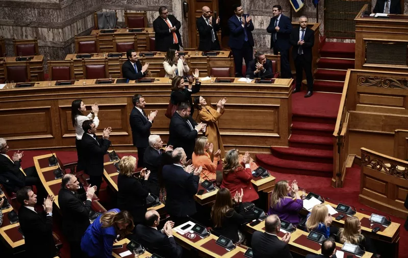 Members of the Greek government applaud during voting parliament on same-sex marriage in Athens, on February 15, 2024. The legalization of same-sex marriage in Greece, adopted by MPs on February 15 evening, is "a turning point for human rights", according to conservative Prime Minister Kyriakos Mitsotakis, who championed the reform. (Photo by Angelos TZORTZINIS / AFP)