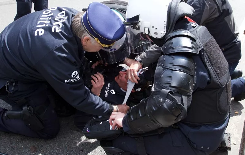 Police captain Pierre Vandersmissen is injured after being hit in the head during a national anti-austerity demonstration on May 24, 2016, in Brussels.
Belgian trade unions called for mass protests against the centre-right government's proposed work reforms as they plan rallies and strikes over the next few months. / AFP PHOTO / BELGA / Nicolas MAETERLINCK / Belgium OUT