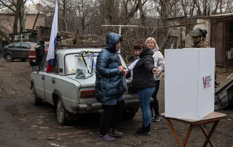 A woman votes at a mobile polling station during early voting in Russia's presidential election in Donetsk, Russian-controlled Ukraine, amid the Russia-Ukraine conflict on March 14, 2024. (Photo by STRINGER / AFP)
