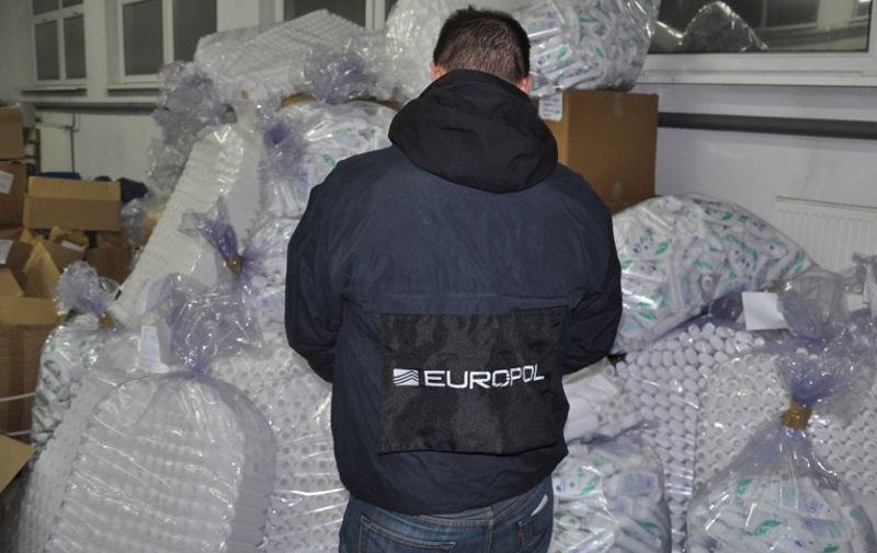 This handout photo released by Polish Police shows a member of Europol standing on December 8, 2012 at the Police warehouse in Olsztyn, northern Poland, by empty shampoo bottles cosmetics seized one day before by Polish policemen. With the support of Europol they dismantled a criminal group behind illegal factories, warehouses and wholesale process of counterfeit cosmetics, shampoos and washing powder. 
RESTRICTED TO EDITORIAL USE - MANDATORY CREDIT " AFP PHOTO /POLICE " - NO MARKETING NO ADVERTISING CAMPAIGNS - DISTRIBUTED AS A SERVICE TO CLIENTS