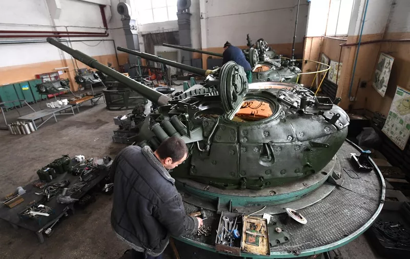 Employees work on tanks turrets in an assembly workshop at Kiev's Armoured Plant on November 15, 2018. The companies of the state concern Ukroboronprom on Thursday gave to the after the handover ceremony of military heavy weapons and the equipment to Ukrainian servicemen taking part in armed conflict with Russia-backed separatists in the country's Donetsk region, more than 65 units of tanks t-72 APC BTR-3E1U, armored cars "Novator" and the 50 units of the newest Ukraine disigned highly accurate anti-tank missile systems Stugna-? and Corsair. (Photo by Sergei SUPINSKY / AFP)