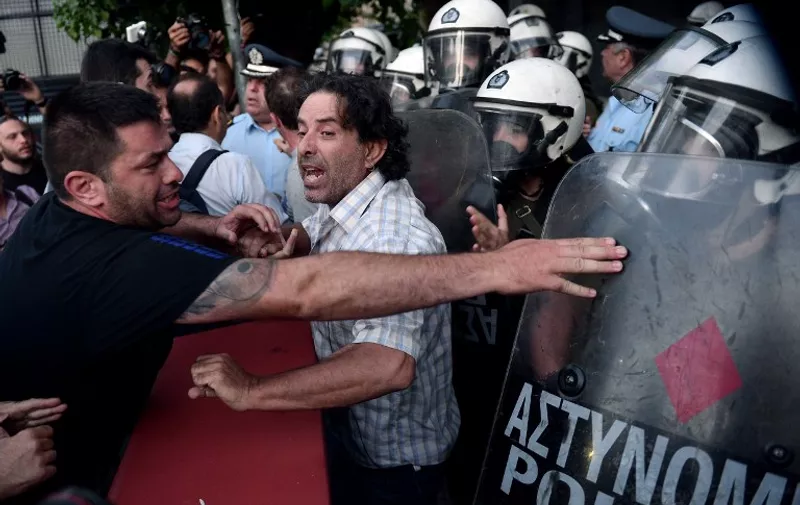 Anti-EU protesters scuffle with police outside the European Comission offices in Athens on July 2, 2015.  Greece's government and international creditors raised the stakes on July 2 over a weekend referendum seen as decisive for the nearly insolvent EU country's political and financial future. While Prime Minister Alexis Tsipras has urged Greeks to vote 'No' to the austerity measures demanded by international creditors, opposition parties including the centre-right New Democracy are campaigning for a 'Yes' vote in the referendum on July 5.  AFP PHOTO / Louisa Gouliamaki