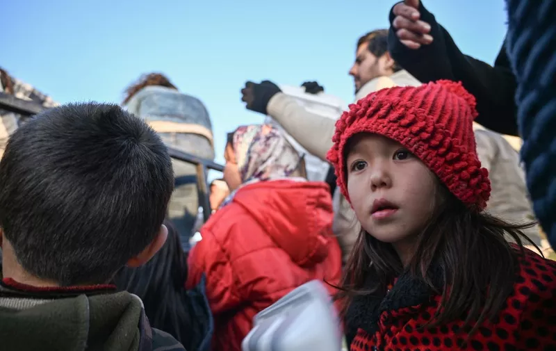 Migrant children wait with adults to receive food near Edirne, northwestern Turkey as they wait to cross the Meritsa river by boat and enter neighbouring Greece on March 2, 2020. - Turkey late last week stopped blocking asylum-seekers from trying to reach the EU, effectively suspending a 2016 EU-Turkey deal that had largely stemmed the flow of Syrians, Afghans, Iranians, Iraqis and others that had overwhelmed Greece in 2015. (Photo by Ozan KOSE / AFP)
