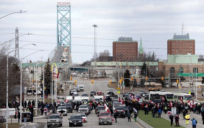Protestors against Covid-19 vaccine mandates block the entrance to the Ambassador Bridge in Windsor, Ontario, Canada, on February 12, 2022. - Police in Canada were positioning Saturday to clear the bridge on the US border, snarled for days by truckers protesting against vaccination rules, an AFP journalist observed. "We urge all demonstrators to act lawfully &amp; peacefully," police in Windsor, Ontario, home to the Ambassador Bridge, tweeted in announcing the deployment. (Photo by JEFF KOWALSKY / AFP)