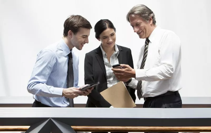 Businessman showing smartphone to colleagues