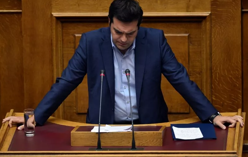 Greek Prime Minister Alexis Tsipras addresses  a session at the  Greek parliament prior the vote in Athens early on July 23, 2015. Prime Minister Alexis Tsipras faced a new test of his authority in parliament on July 22, where MPs were to vote on a second batch of reforms to help unlock a bailout for Greece's stricken economy. The embattled premier last week faced a revolt by a fifth of the lawmakers in his radical-left Syriza party over changes to taxes, pensions and labour rules demanded by EU-IMF creditors. AFP PHOTO/ LOUISA GOULIAMAKI