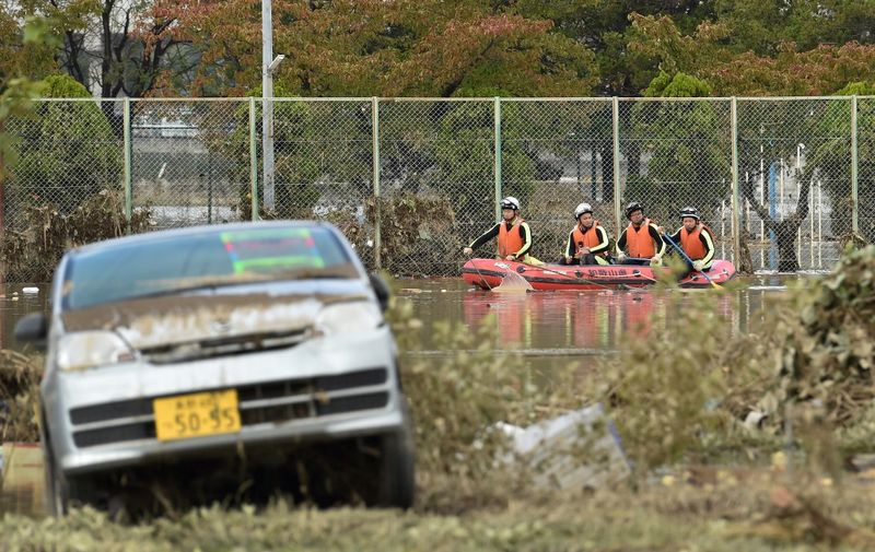 Emergency personnel paddle across floodwaters during search and rescue operations in the aftermath of Typhoon Hagibis in Nagano on October 14, 2019. - Tens of thousands of rescue workers were searching on October 14 for survivors of powerful Typhoon Hagibis, two days after the storm slammed into Japan, killing at least 35 people. (Photo by Kazuhiro NOGI / AFP)