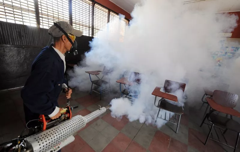 Health ministry personnel fumigate against the Aedes aegypti mosquito, vector of the dengue, Chikungunya and Zika viruses in Tegucigalpa, , on February 1, 2016. Honduran President Juan Orlando Hernandez on Friday declared the country on a preventive state of alert due to the Zika virus which in the last 44 days killed a person and infected some 1000.      AFP PHOTO/Orlando SIERRA. / AFP / ORLANDO SIERRA