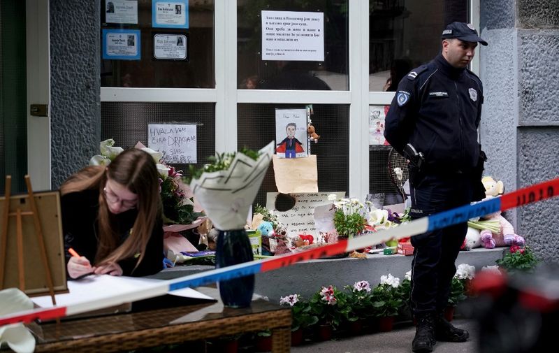 People sign the book of condolences outside the Vladislav Ribnikar elementary school in the capital Belgrade, on May 5, 2023, two days after a 13-year-old suspect shot dead eight fellow students and a security guard after allegedly drawing up a kill list. - Serbian President vowed to launch a large-scale disarmament plan to remove hundreds of thousands of guns from the country following two mass shootings in less than 48 hours. (Photo by Oliver Bunic / AFP) / The erroneous mention appearing in the metadata of this photo by Oliver Bunic has been modified in AFP systems in the following manner: [May 5, 2023] instead of [May 4, 2023]. Please immediately remove the erroneous mention from all your online services and delete it from your servers. If you have been authorized by AFP to distribute it to third parties, please ensure that the same actions are carried out by them. Failure to promptly comply with these instructions will entail liability on your part for any continued or post notification usage. Therefore we thank you very much for all your attention and prompt action. We are sorry for the inconvenience this notification may cause and remain at your disposal for any further information you may require.