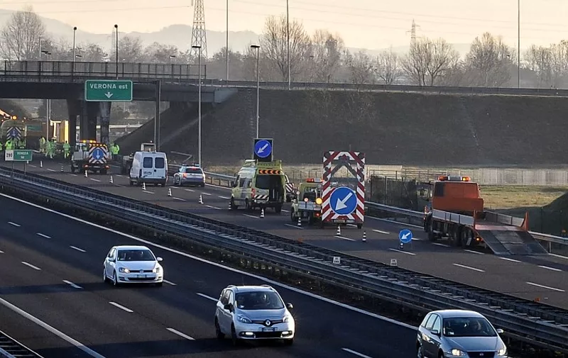 A view of the motorway A4 near the Verona East exit, with the workers who clean on January 21, 2017. Sixteen people died when a bus carrying Hungarian teenagers crashed and caught fire on a motorway in northern Italy, firefighters said Saturday. PHOTO / Claudio MARTINELLI