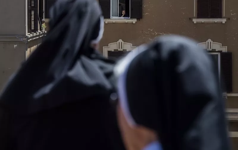The nuns Apostles of Holy Heart of Jesus celebrate a prayer on the roof of their nunnery, some people follow the prayer from the windows of their home
Coronavirus outbreak, Rome, Italy - 28 Apr 2020,Image: 515705199, License: Rights-managed, Restrictions: , Model Release: no