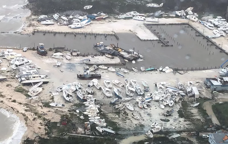 In this image courtesy of US Coast Guard Air Station Clearwater, boats are strewn across a marina in in Andros Island, Bahamas, on September 2, 2019, as Hurricane Dorian makes its way across the Bahamas. - Dorian crept towards the southeast coast of the US on September 3, 2019, weakening slightly but remaining a dangerous storm after leaving a trail of death and destruction in the Bahamas. At least five deaths have been reported in the Bahamas from a storm which Prime Minister Hubert Minnis called a "historic tragedy" for the Atlantic archipelago.The Miami-based National Hurricane Center said Dorian, which has dumped as much as 30 inches (76 centimeters) of rain on the Bahamas, had been downgraded from a Category 3 to a Category 2 storm on the five-level wind scale. (Photo by HO / US Coast Guard / AFP) / RESTRICTED TO EDITORIAL USE - MANDATORY CREDIT "AFP PHOTO / US COAST GUARD" - NO MARKETING NO ADVERTISING CAMPAIGNS - DISTRIBUTED AS A SERVICE TO CLIENTS