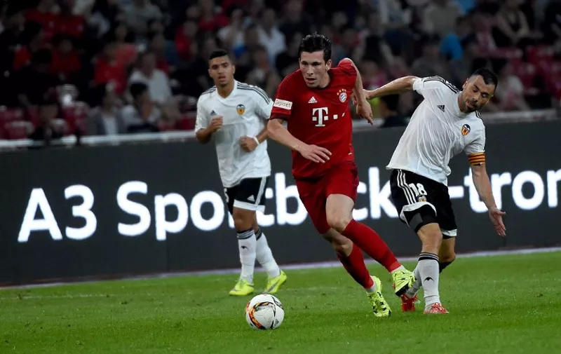 Bayern Munich's midfielder Pierre Emile Hojbjerg (C) vies for the ball with Valencia's midfielder Javier Fuegoduring a friendly football match between Bayern Munich and Valencia at the Bird's Nest stadium in Beijing on July 18, 2015.      AFP PHOTO / WANG ZHAO