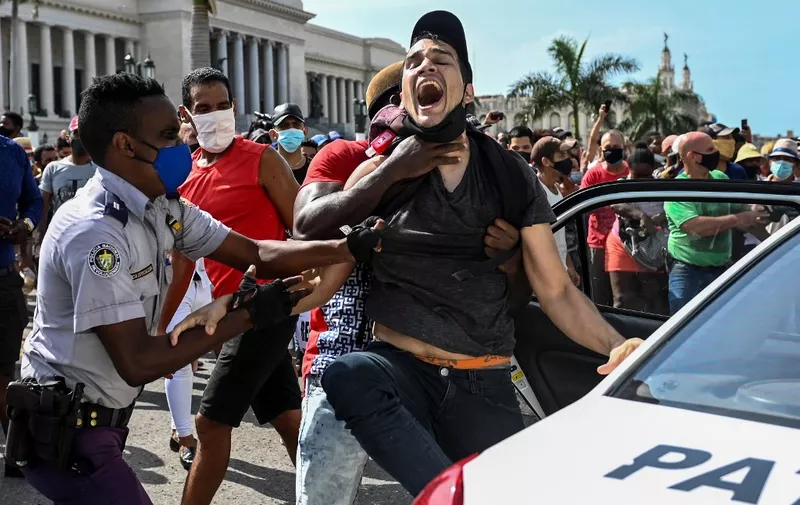 A man is arrested during a demonstration against the government of Cuban President Miguel Diaz-Canel in Havana, on July 11, 2021. - Thousands of Cubans took part in rare protests Sunday against the communist government, marching through a town chanting "Down with the dictatorship" and "We want liberty." (Photo by YAMIL LAGE / AFP)
