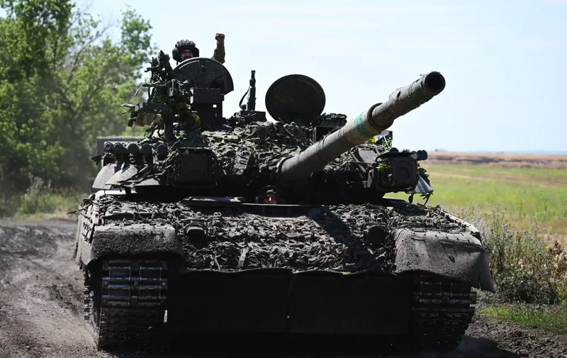 Ukrainian servicemen drive a T-72 tank on the frontline in eastern Ukraine on July 13, 2022, amid the Russian invasion of Ukraine. (Photo by MIGUEL MEDINA / AFP)