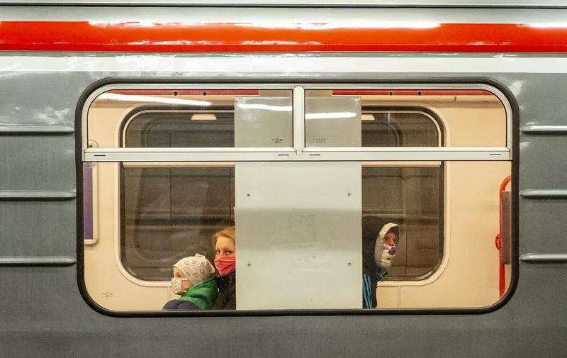 Passengers, wearing face masks, sit in a train at a subway station in Prague on April 15, 2020 amid restrictions due to the new coronavirus pandemic. (Photo by Michal Cizek / AFP)