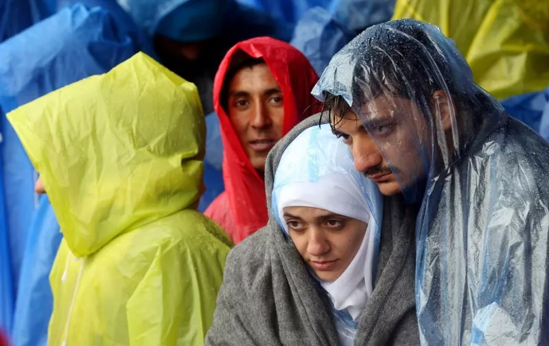 Migrants and refugees wait in the rain as they wait to enter Slovenia, at the Croatian-Slovenian border in Trnovec, on October 19, 2015. Slovenian authorities said today they had refused to let in more than 1,000 migrants arriving from Croatia after a daily quota had been reached, stoking fears of a new human bottleneck on the western Balkan route.  AFP PHOTO /