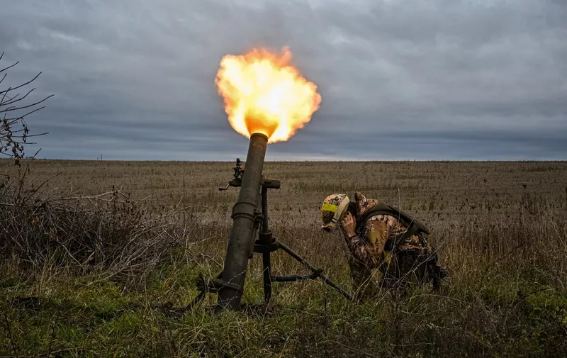 A member of Ukrainian National Guard fires a mortar launcher at a position along the front line in Kharkiv region on October 25, 2022, amid the Russian invasion of Ukraine. (Photo by SERGEY BOBOK / AFP)