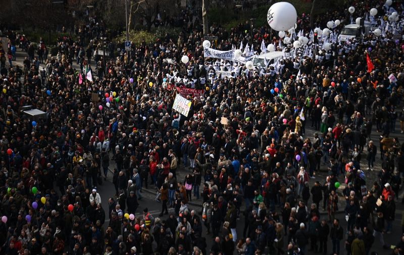Protesters holding flags of the CFE-CGC's trade union attend a demonstration on the fourth day of nationwide rallies organised since the start of the year, against a deeply unpopular pensions overhaul, in Paris on February 11, 2023. (Photo by Christophe ARCHAMBAULT / AFP)