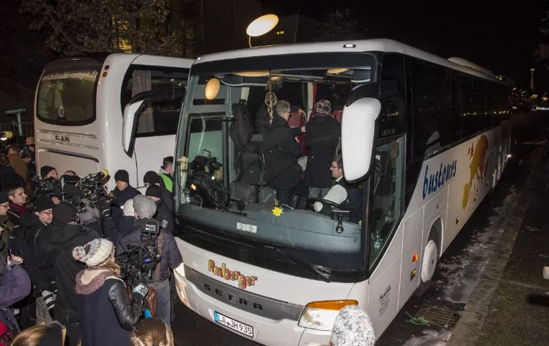 Reporters surround a bus carrying refugees parked in front of the chancellery in Berlin on January 14, 2016, after it arrived from the Bavarian city of Landshut.
The bus was chartered by Landshut district administrator Peter Dreier who complained to German Chancellor Angela Merkel in October 2015 about the high number of refugees settling in his area, and vowed to send any refugees who went over his fixed quota "to the chancellery in Berlin".  / AFP / John MACDOUGALL