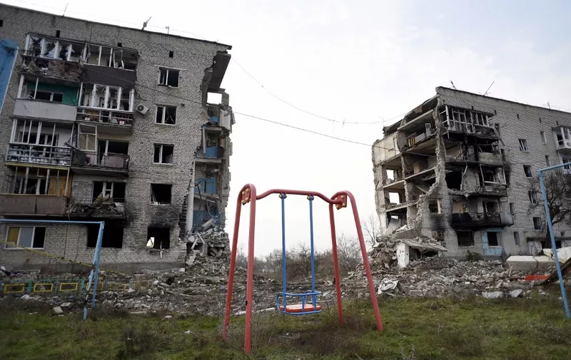 IZIUM, UKRAINE - DECEMBER 25, 2022 - A swing facing a residential building ruined by Russian shelling is pictured in Izium which was liberated from Russian occupiers, Kharkiv Region, northeastern Ukraine.NO USE RUSSIA. NO USE BELARUS. (Photo by Kaniuka Ruslan / NurPhoto / NurPhoto via AFP)