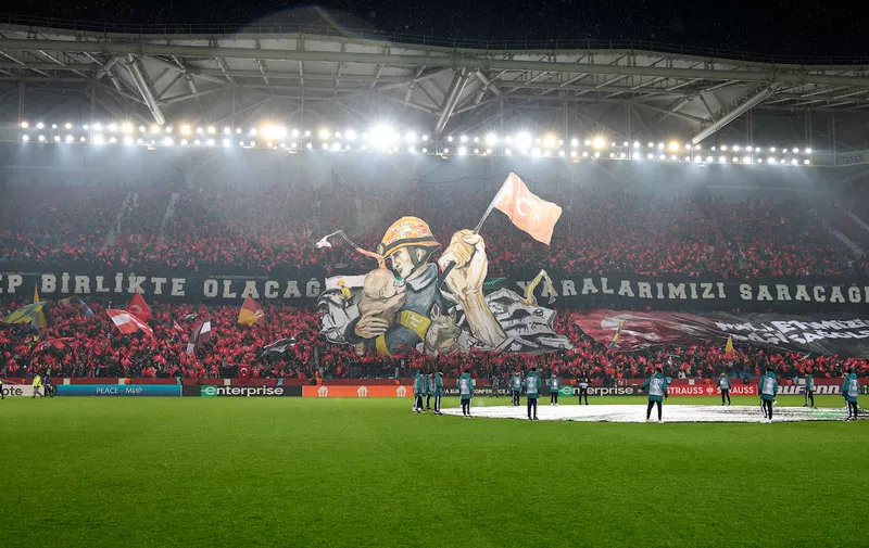 Fans show picture to honor of victims of earthquake in Turkey and Syria prior to the start of a Europa Conference League playoff first leg soccer match between Trabzonspor and Basel at the Senol Gunes stadium in Trabzon, Turkey, Thursday, Feb. 16, 2023. (AP Photo)
