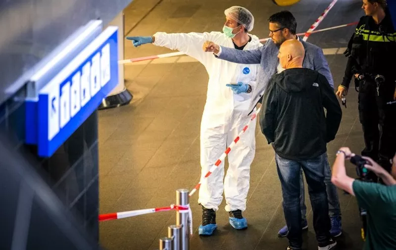 Policemen and forensics are at work after a stabbing incident at the central station in Amsterdam, on August 31, 2018.  
The Police have shot a suspect after two people were stabbed. The stabbing was possibly an act of terrorism, said the police. The suspect and two other people who were injured in the stabbing incident were taken to hospital. / AFP PHOTO / ANP / Remko de Waal / Netherlands OUT
