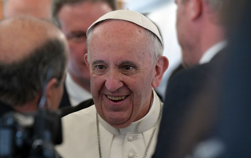 Pope Francis smiles as he talks to journalists during his flight to Portugal prior to visiting Fatima shrine, in Fatima on May 12, 2017. 
Two of the three child shepherds who reported apparitions of the Virgin Mary in Fatima, Portugal, one century ago, will be declared saints on May 13, 2017 by Pope Francis.
The canonisation of Jacinta and Francisco Marto will take place during the Argentinian pontiff's visit to a Catholic shrine visited by millions of pilgrims every year. / AFP PHOTO / Tiziana FABI