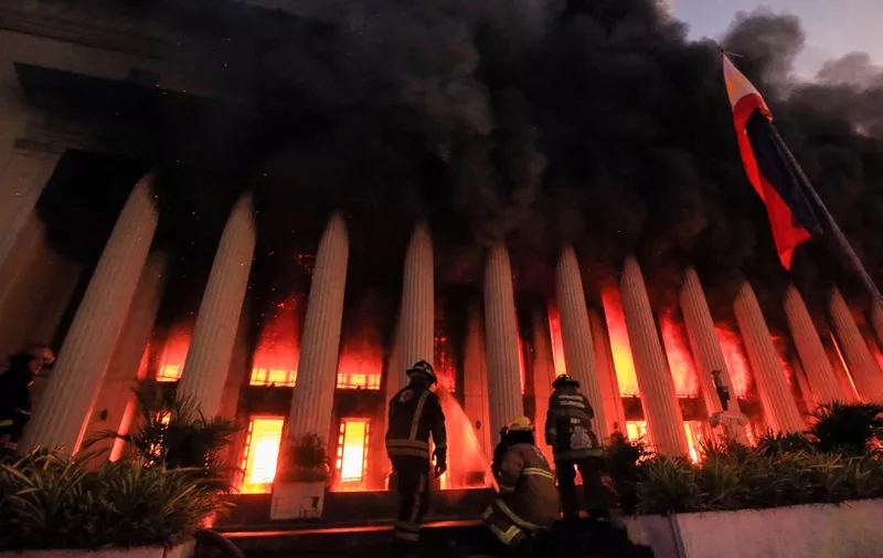 Firefighters douse a fire at the Post Office building in Manila on May 22, 2023. (Photo by AFP)