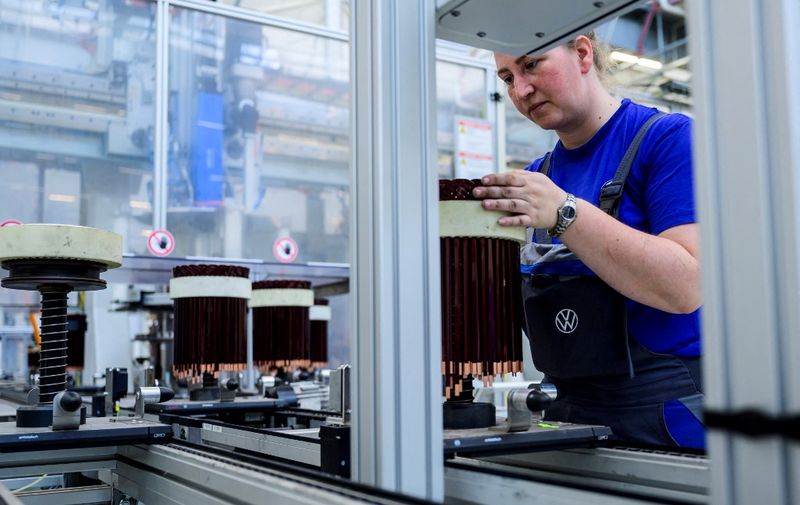 A worker checks a stator, a component for Volkswagen's electric motor found in their ID models, on an assembly line at the VW component plant in Salzgitter, north-central Germany, on May 18, 2022. - A 16 gigawatt hour battery cell factory will be built next to the component plant in 2020, with production to start in late 2023/early 2024 in a 50/50 joint venture with Swedish battery producer Northvolt. (Photo by John MACDOUGALL / AFP)