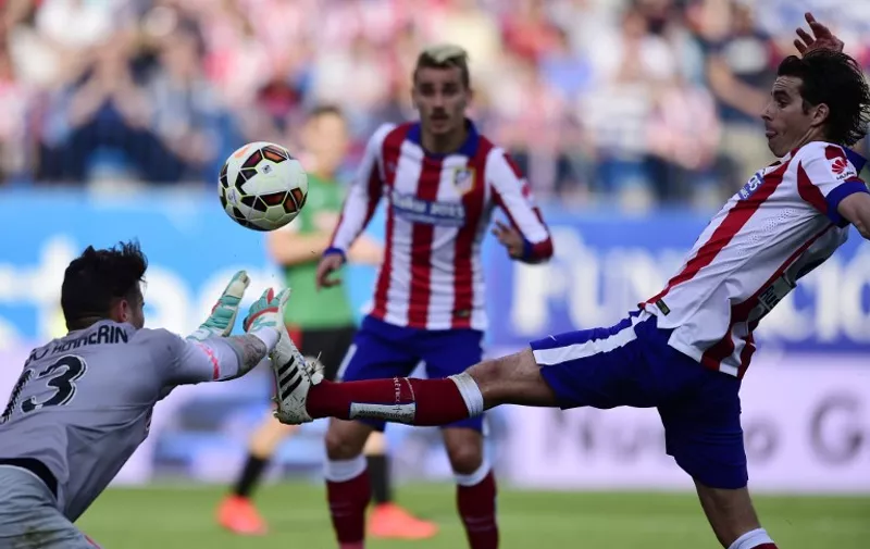 Atletico Madrid's Portuguese midfielder Tiago (R) vies with Athletic Bilbao's goalkeeper Iago Herrerin during the Spanish league football match Club Atletico de Madrid vs Athletic Club Bilbao at the Vicente Calderon stadium in Madrid on May 2, 2015.  AFP PHOTO/