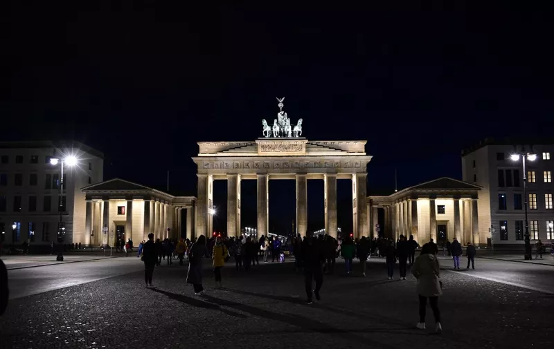 The illuminated Berlin's Brandenburg Gate is pictured before the so-called 'Earth Hour', on March 26, 2022. - Earth Hour, organized by the World Wide Fund for Nature (WWF), is held annually encouraging individuals, communities, and businesses to turn off non-essential electric lights, for one hour, from 8:30 to 9:30 p.m. on a specific day towards the end of March as a symbol of commitment to the planet. (Photo by Tobias SCHWARZ / AFP)