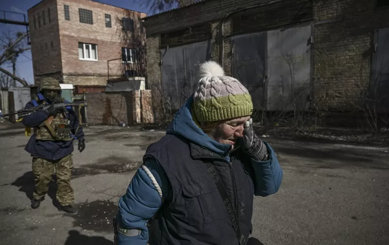 A resident cries as she evacuates the city of Irpin, north of Kyiv, on March 10, 2022. - Russian forces on March 10, 2022 rolled their armoured vehicles up to the northeastern edge of Kyiv, edging closer in their attempts to encircle the Ukrainian capital. Kyiv's northwest suburbs such as Irpin and Bucha have been enduring shellfire and bombardments for more than a week, prompting a mass evacuation effort. (Photo by Aris Messinis / AFP)