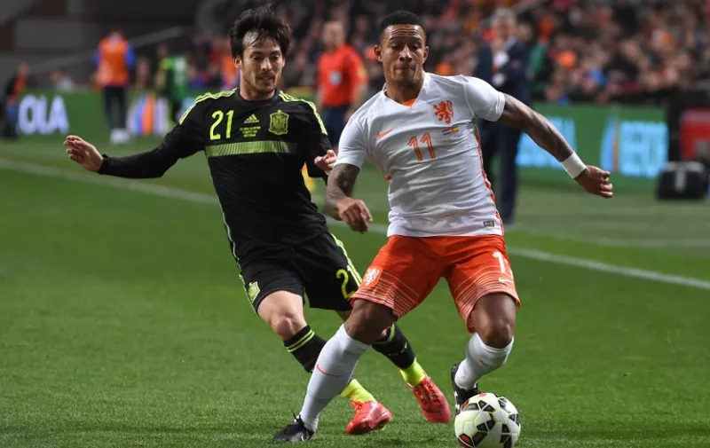 Netherland's Memphis Depay (R) vies with Spain's David Silva during the  friendly football match Netherlands vs Spain in Amsterdam, on March 31, 2015. AFP PHOTO/Emmanuel Dunand