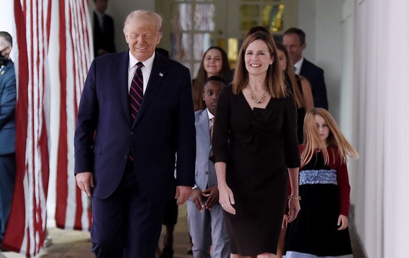 US President Donald Trump (L) and Judge Amy Coney Barrett (R), arrive at the Rose Garden of the White House in Washington, DC, on September 26, 2020. - Judge Amy Coney Barrett, who was nominated Saturday to the US Supreme Court, is a darling of conservatives for her religious views but detractors warn her confirmation would shift the nation's top court firmly to the right. (Photo by Olivier DOULIERY / AFP)
