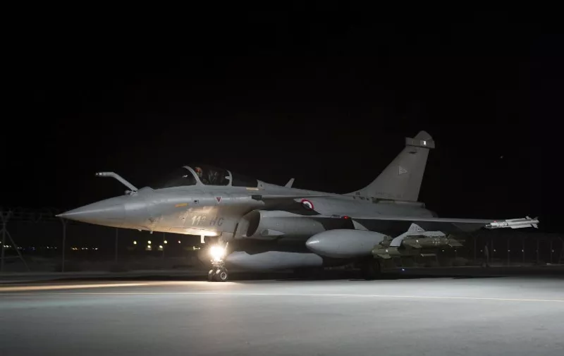 A handout picture taken on October 23, 2014 and released on October 24, 2014 by the French Army Communications body ECPAD (Establishment of Communication and Audiovisual Production of Defense) shows one of the French Rafale fighter jets that took part in air strikes in the night of October 23 against in the Islamic State (IS) group south of Mosul in the Kirkuk region of northern Iraq, parked at Al-Dhafra base in the United Arab Emirates. The international coalition currently battling the Islamic State group in Iraq dropped around 70 bombs on an arsenal and jihadist training centre in a large-scale overnight raid, the French military said on OCtober 24. France's Rafale fighter jets took part in the operation, which destroyed buildings in which IS militants "produced their traps, their bombs, their weapons to attack Iraqi forces" added France's Chief of the Defence Staff. AFP PHOTO / ECPAD
= RESTRICTED TO EDITORIAL USE - MANDATORY CREDIT "AFP PHOTO / ECPAD" - NO MARKETING NO ADVERTISING CAMPAIGNS - DISTRIBUTED AS A SERVICE TO CLIENTS - TO BE USED WITHIN 30 DAYS FROM 10/24/2014 =