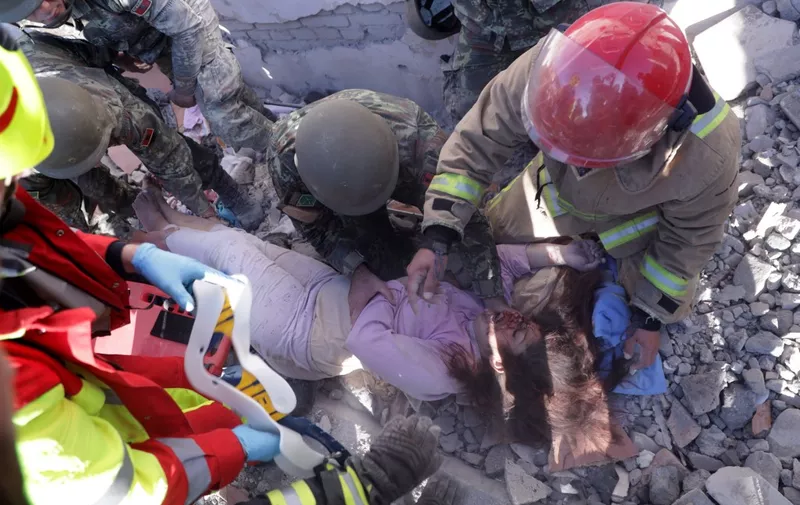 Rescuers help a survivor after saving him from the rubble of a collapsed building in Thumane, northwest of capital Tirana, after an earthquake hit Albania, on November 26, 2019. - Albanian rescuers dug through rubble as desperate survivors trapped in toppled buildings cried out for help Tuesday after the strongest earthquake in decades killed at least 16 people and left hundreds injured.
The 6.4 magnitude quake struck before dawn at 3:54 am local time (0254 GMT), with an epicentre 34 kilometres (about 20 miles) northwest of the capital Tirana, according to the European-Mediterranean Seismological Centre. (Photo by STRINGER / AFP)