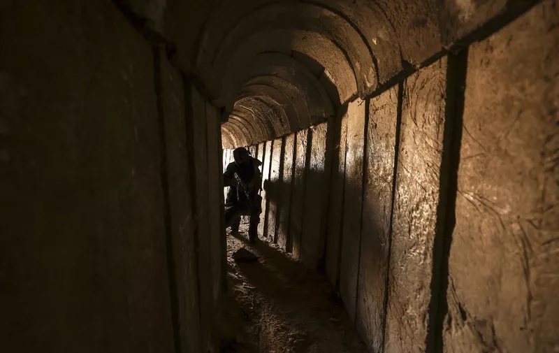 A member of the Palestinian Islamic Jihad militant group walks in a tunnel in the Gaza strip, on April 17, 2022, during a media tour amid escalating violence with Israel. More than 20 Palestinians and Israelis were wounded in several incidents in and around Jerusalem's flashpoint Al-Aqsa Mosque complex, two days after major violence at the site. (Photo by Mahmud HAMS / AFP)