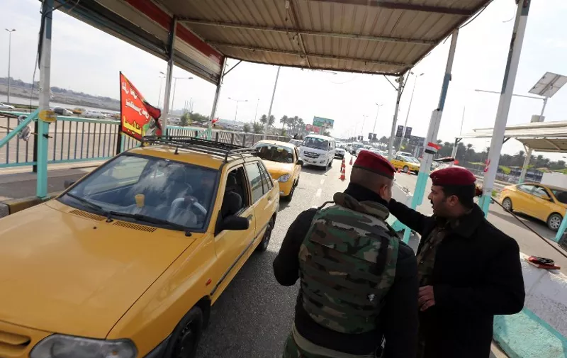 Iraqi security forces man a checkpoint on the main road from Baghdad's central Jaderiyah district to Dora on the southern outskirts of the Iraqi capital on January 18, 2016. 
US and Iraqi authorities were searching for three missing Americans said to have been kidnapped in southern Baghdad, the latest group of foreign nationals abducted in recent months.
 / AFP / SABAH ARAR