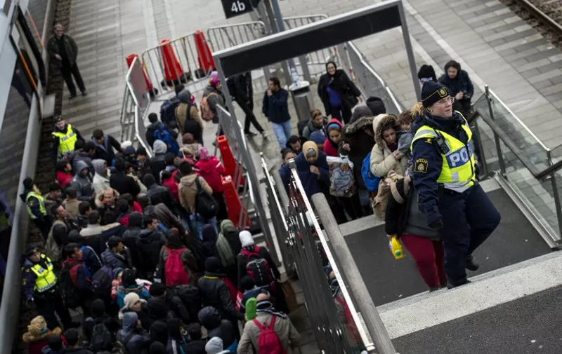 Police organize the line of refugees on the stairway leading up from the trains arriving from Denmark at the Hyllie train station outside Malmo, Sweden, November 19, 2015. 600 refugees arrived in Malmo within 3 hours and the Swedish Migration Agency said in a press statement that they no longer can guarantee accommodation for all asylum seekers.     AFP PHOTO / TT NEWS AGENCY / JOHAN NILSSON    +++   SWEDEN OUT   +++ / AFP / TT NEWS AGENCY / JOHAN NILSSON