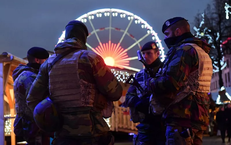Belgian soldiers patrol during the opening night of the annual Christmas market on November 27, 2015 in Brussels. Belgium reduced the terrorism alert in Brussels from its highest possible level on November 26 after Prime Minister Charles Michel said the threat of a Paris-style jihadist attack was no longer as imminent. AFP PHOTO / EMMANUEL DUNAND / AFP / EMMANUEL DUNAND