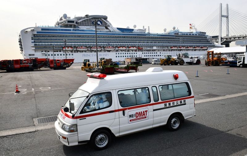 An ambulance is seen before the quarantined Diamond Princess cruise ship at Daikoku Pier Cruise Terminal in Yokohama on February 7, 2020, to transfer patients who tested positive for the new coronavirus. - Another 41 people on a cruise ship quarantined off Japan have the new coronavirus, the country's health minister said on February 7, confirming more on board will now be tested for the illness. (Photo by Kazuhiro NOGI / AFP) / The erroneous mention[s] appearing in the metadata of this photo by Kazuhiro NOGI has been modified in AFP systems in the following manner: [YOKOHAMA] instead of [TOKYO]. Please immediately remove the erroneous mention[s] from all your online services and delete it (them) from your servers. If you have been authorized by AFP to distribute it (them) to third parties, please ensure that the same actions are carried out by them. Failure to promptly comply with these instructions will entail liability on your part for any continued or post notification usage. Therefore we thank you very much for all your attention and prompt action. We are sorry for the inconvenience this notification may cause and remain at your disposal for any further information you may require.
