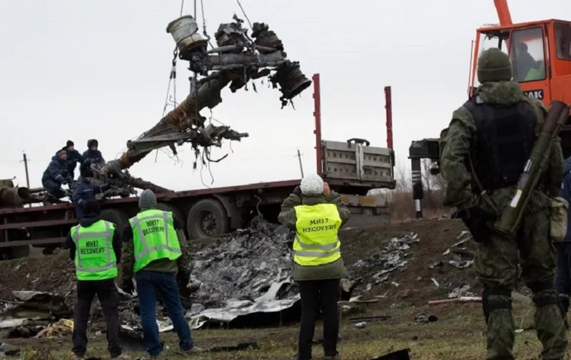 Members of the Dutch expert team watch as parts of the wreckage of the Malaysia Airlines Flight MH17 are removed and loaded on a truck at the crash site near the village of Grabove in eastern Ukraine, on November 16 2014. Work began  to remove the wreckage of Malaysia Airlines flight MH17 from rebel-held territory in eastern Ukraine, four months after it was shot down claiming 298 lives. AFP PHOTO / MENAHEM KAHANA / AFP PHOTO / MENAHEM KAHANA