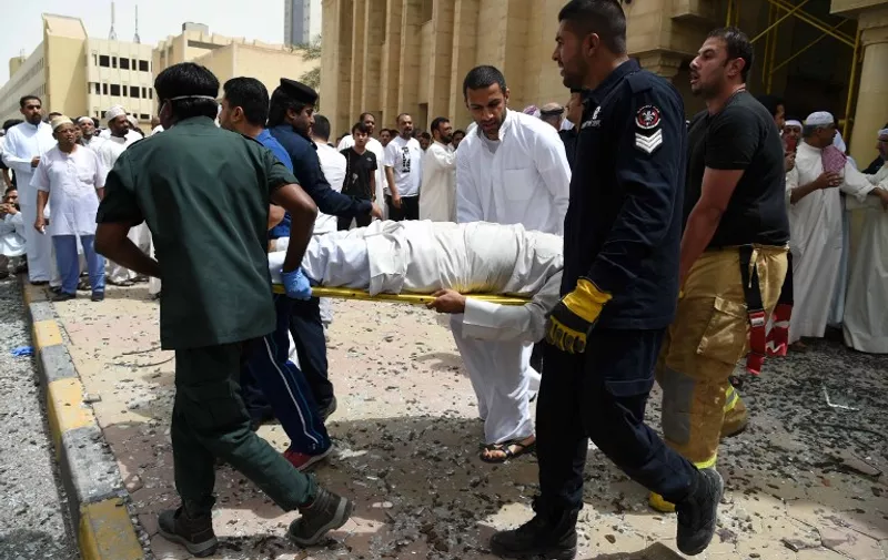Kuwaiti security personnel and medical staff carry a man on a stretcher at the site of a suicide bombing that targeted the Shiite Al-Imam al-Sadeq mosque after it was targeted by a suicide bombing during Friday prayers on June 26, 2015, in Kuwait City. The Islamic State group-affiliated group in Saudi Arabia, calling itself Najd Province, said militant Abu Suleiman al-Muwahhid carried out the attack, which it claimed was spreading Shiite teachings among Sunni Muslims. AFP PHOTO / STR